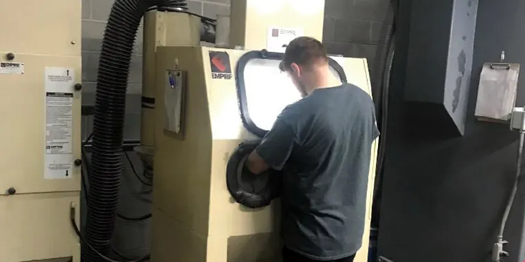 Technician at the cleaning cabinet preparing turbocharger housings