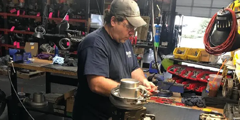 Technician rebuilding a turbocharger at a workbench in the Pennsauken shop