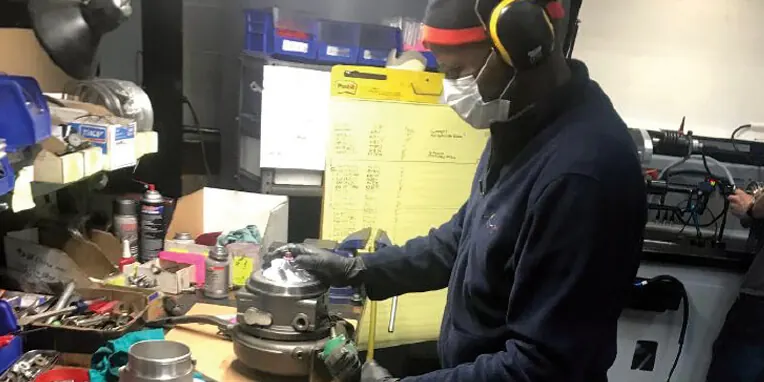 Technician in protective gear working on a turbocharger